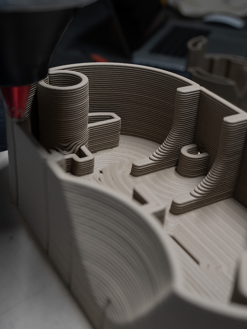 Clay is printed on a custom generated path, finding its way around the standard components in a single continuous line.
