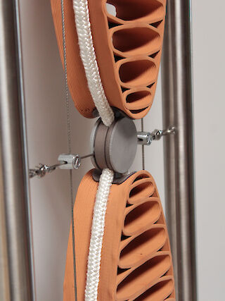 Seilklemme, sattelt und sichert die Tonteile, hält die Tonteile zueinander in Distanz, fixiert die Kühlstränge