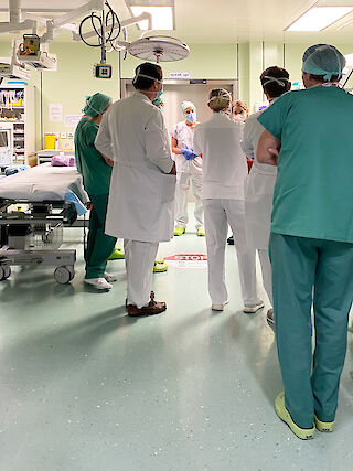 Die Sanitäter:innen übergeben den Patienten, das Team nimmt den Bericht entgegen. Schockraum, USZ